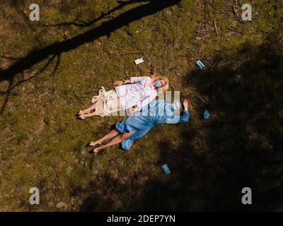 Due medici in maschere chirurgiche che si trovano in foresta e chiacchierando Foto Stock