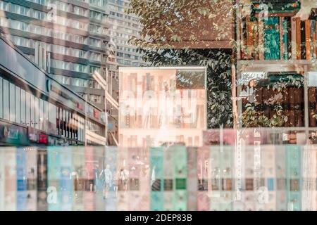 Astratto sfondo offuscato di librerie di libreria con libri colorati e riflessi nella vetrata dei marciapiedi della città con non riconoscibile p Foto Stock