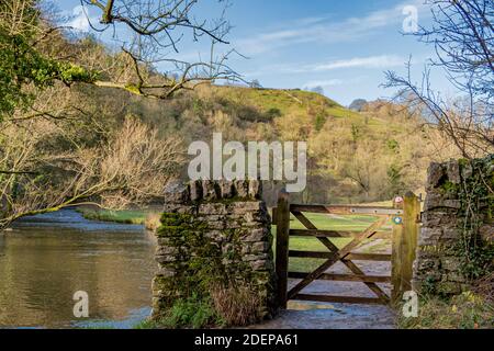 Una passeggiata nella bellissima valle di Dovedale in direzione di Milldale la foto mostra il fiume e un cancello sul sentiero proprio come la valle si allarga Foto Stock