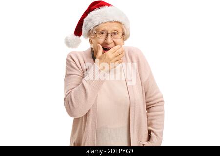 Donna anziana con un cappello di babbo natale che tiene la mano contro la bocca e sorridente isolato su sfondo bianco Foto Stock