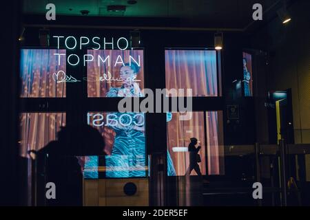 Londra: 1 dicembre 2020. Un pedestrain e un negozio rivale si riflettono nella finestra del personale chiuso e vuoto ingresso a Topshop e Miss Selfridges, su Oxford Street l'ultimo giorno del secondo blocco. Il 30 novembre 2020 fu annunciato che Topshop, di proprietà del Gruppo Arcadia, era entrato in amministrazione. Credit: Tom Leighton/Alamy Live News Foto Stock