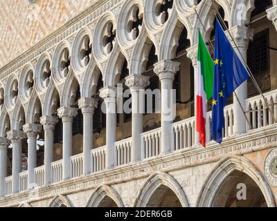 Bandiere italiane ed europee appendono rom la loggia del Palazzo Ducale sopra la galleria al piano terra - Venezia, Veneto, Italia Foto Stock