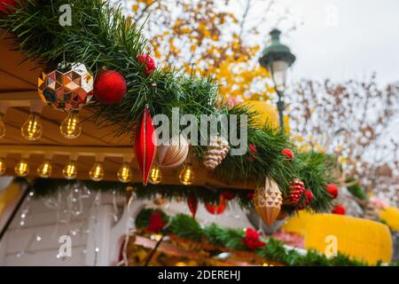 Ornamenti di Natale su un supporto alimentare. Mercatino di Natale, Parigi (Giardini delle Tuileries), Francia. Bellissimo stand in legno decorato durante l'inverno di dicembre Foto Stock