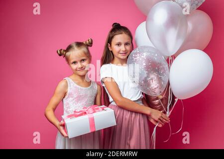 ritratto di una ragazza adolescente su sfondo rosa, con regali, concetto di compleanno Foto Stock