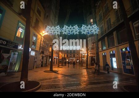 Malaga, Spagna. 01 dicembre 2020. La gente cammina lungo una piazza vuota di Felix Saenz decorata con luci di natale dopo una chiusura obbligatoria delle attività non essenziali, in mezzo alla pandemia del coronavirus. Il governo andaluso dice che la regione ha battuto la curva della seconda ondata. Nel tentativo di prevenire la diffusione della malattia del coronavirus, l'Andalusia manterrà la continuità delle restrizioni obbligatorie fino al 10 dicembre. Credit: SOPA Images Limited/Alamy Live News Foto Stock