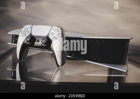 PlayStation 5 al suo fianco con il controller DualSense Foto Stock