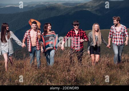 Gruppo di giovani che camminano sulla natura estiva all'aperto. Gruppi di amici che si rilassano si godono all'aperto. Foto Stock