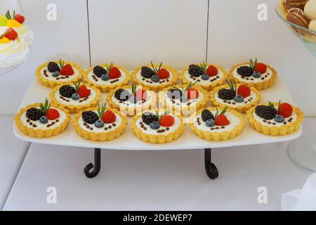 Mini dessert con frutta fresca sul supporto. Foto Stock