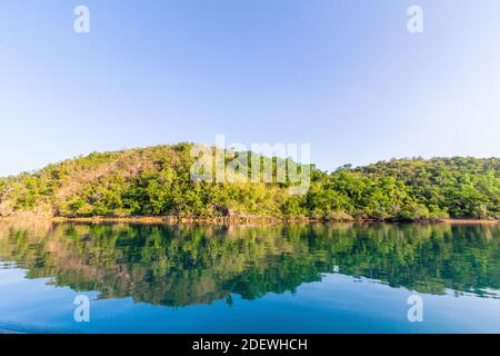 Colline riflesse su acque calme in un'isola di Palawan, Filippine Foto Stock