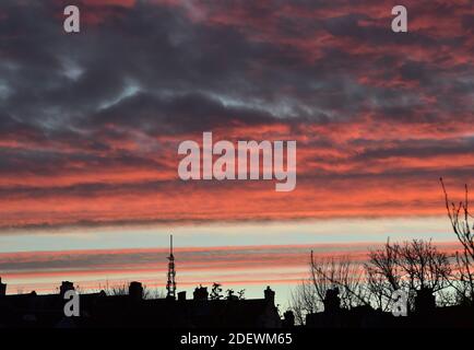 Brighton UK 2 dicembre 2020 - UNA spettacolare alba sui tetti e la stazione di trasmissione di Whitehawk Hill a Brighton Est questa mattina: Credit Simon Dack / Alamy Live News Foto Stock