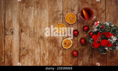 VIN brulé di Natale in una tazza di vetro su un tavolo di legno con arance secche Foto Stock