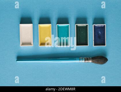 pennello scoiattolo e vernici acquerello con spazio di copia, vista dall'alto, luce del giorno. Concetto di spazio di lavoro dell'artista Foto Stock