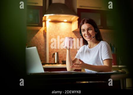 Lavoratore facendo una domanda mentre solleva il suo tè Foto Stock