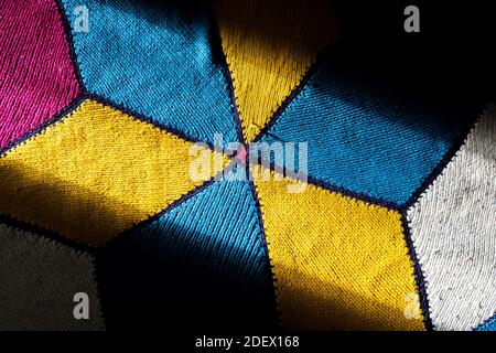 La luce del sole viene sul tappeto tovuto della mano turca. Il tappeto tessuto a mano ha colori giallo, blu, rosso e bianco. Moquette tradizionale. Foto Stock