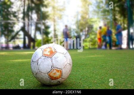 calcio di strada. vecchia palla sull'erba verde del campo. sport attivi Foto Stock