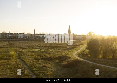 Città di Zutphen visto dall'altra parte del fiume IJssel con La torre Walburgiskerk nella piazza centrale e nelle pianure alluvionali il primo piano Foto Stock