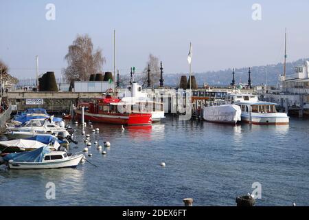 GINEVRA, SVIZZERA - 20 febbraio 2018: Viaggio in città a Ginevra durante l'inverno. L'immagine mostra le barche sul lago con le montagne sullo sfondo. Foto Stock