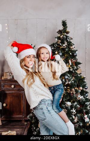 Divertente Ritratto di famiglia felice nel cappello di babbo natale con regali di Natale a casa. Felice anno nuovo Foto Stock
