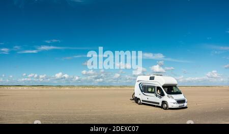 Camping Car RV in piedi su sabbia vuota spiaggia panoramica in giornata di sole. Romo Bilstrand, Lakolk Strand, Danimarca. Foto Stock