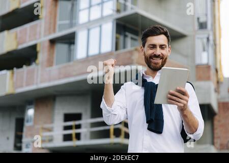 Ingegnere in piedi in cantiere e utilizzando tablet Foto Stock