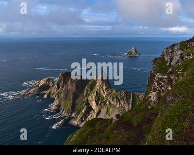 Splendida vista sulla costa nord-occidentale dell'isola di Andøya, Vesterålen, Norvegia, con aspre montagne e scogliere, nonché la popolare roccia di uccelli Bleiksøya. Foto Stock