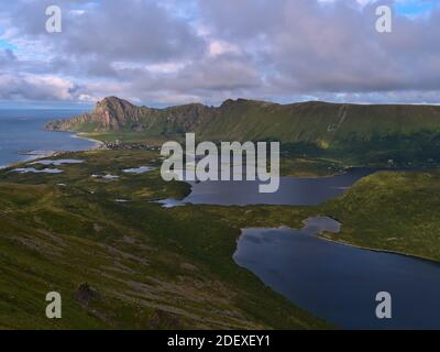 Splendida vista panoramica aerea del lago Bleiksvatnet, Bleikmorenen riserva naturale e villaggio di pescatori Bleik circondato da montagne situato in Norvegia. Foto Stock