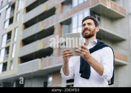 Progettare utilizzando un tablet per confrontare un progetto di costruzione Foto Stock