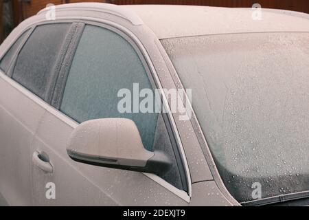 Primo piano dei finestrini di Frozen Car durante la stagione invernale. Strato di gelo Foto Stock