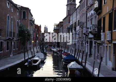 VENEZIA, ITALIA - 23 settembre 2016: Canale tipico con barche e case storiche a Venezia la sera dopo il tramonto. Italia Foto Stock