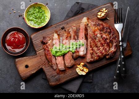 Bistecca di manzo affettato con salse. Sul tagliere. Vista dall'alto in piano Foto Stock