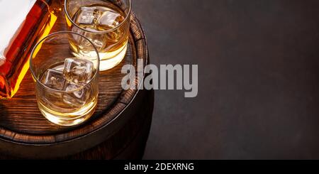 Bottiglia di whiskey Scotch, bicchieri e vecchia botte di legno. Con spazio per la copia Foto Stock