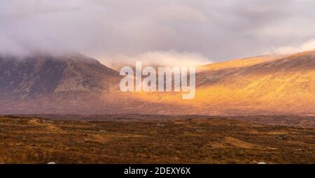 guardando attraverso rannoch brughiera il sole colpisce la valle tra beinn a chrulaiste e meall bannach, tutto il resto id avvolto in nebbia Foto Stock