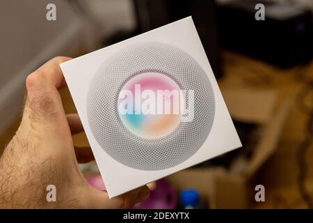 Francoforte, Germania - 17 novembre 2020: POV di mano maschile unboxing pacchetto di ultimi Apple computer HomePod Mini nuovo piccolo altoparlante intelligente con suono potente e assistente personale Siri Foto Stock