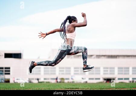Foto d'inventario di un velocista afroamericano che salta negli sport centro Foto Stock