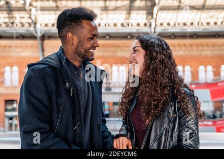 Stock foto di felice momento di coppia interracial di amanti che si guardano l'un l'altro. Sono nella città di Madrid Foto Stock