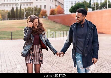 Stock foto di felice momento di coppia interracial tenendo le mani e guardando l'un l'altro. Sono nella città di Madrid Foto Stock
