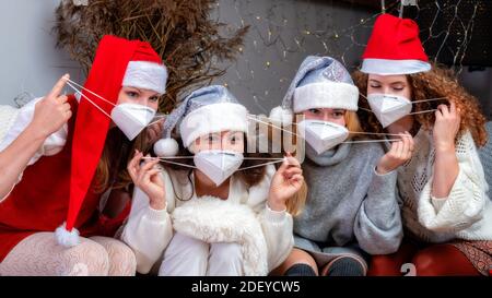 Gruppo di giovani donne felici in Natale santa cappelli e. maschere faccia prendere un auto-ritratto di vacanza Foto Stock