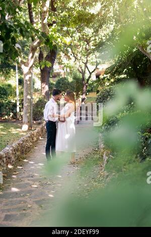 Foto d'inventario di carina donna incinta e suo marito che ha un momento romantico in un parco. Foto Stock
