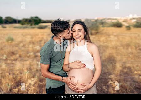 Foto di scorta di una coppia simpatica sorridente e guardando la fotocamera in campagna. Foto Stock