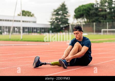 Foto di stock di atleta disabile che prende una pausa e legando i suoi allenatori. Concetto Paralimpico Sport. Foto Stock