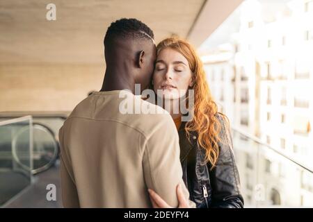 Foto d'inventario di una giovane coppia multietnica che si agganata. Foto Stock