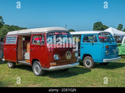 Due autobus volkswagon uno accanto all'altro con diverse vernici personalizzate restauro ad una mostra di auto che si riunisce all'aperto su un soleggiato giorno in estate Foto Stock