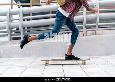 Foto d'inventario di un ragazzo afro non riconosciuto che fa skate in città. Foto Stock