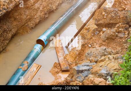 riparare la tubazione rotta e il flusso d'acqua nel foro Foto Stock
