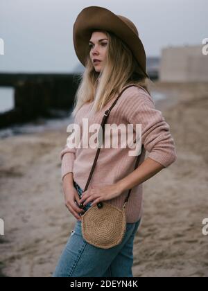 Ragazza in cappello in mare con una borsa di iuta fatta a mano Foto Stock