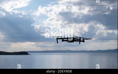 Drone nero, concetto di quadrocopter. Un veicolo aereo senza equipaggio o senza equipaggio (uav), moderno, senza fili, controllato da un operatore. Spia tempi moderni. Sfocatura c Foto Stock