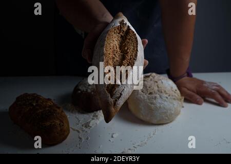 Cuocere l'uomo che tiene in mano un grande pane Foto Stock