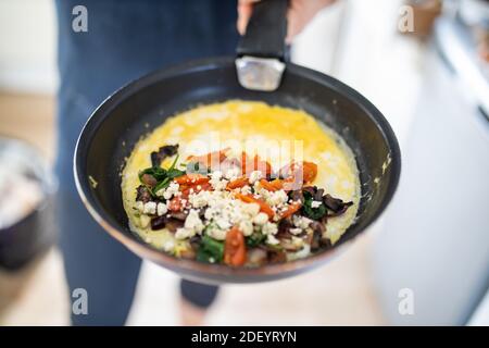 Omelette di funghi, pomodoro e formaggio su una padella Foto Stock