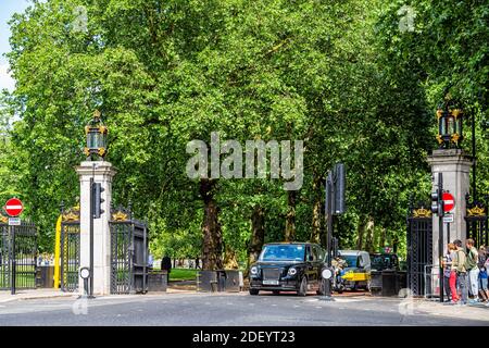 Londra, UK - 21 giugno 2018: Strada con auto nel traffico da Buckingham Palace cancello e Green Park con alberi in estate Foto Stock