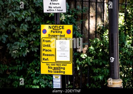Londra, Regno Unito - 22 giugno 2018: Strada con closeup di nessun segnale di parcheggio sospeso nel centro urbano di Londra nel Regno Unito con testo in inglese Foto Stock